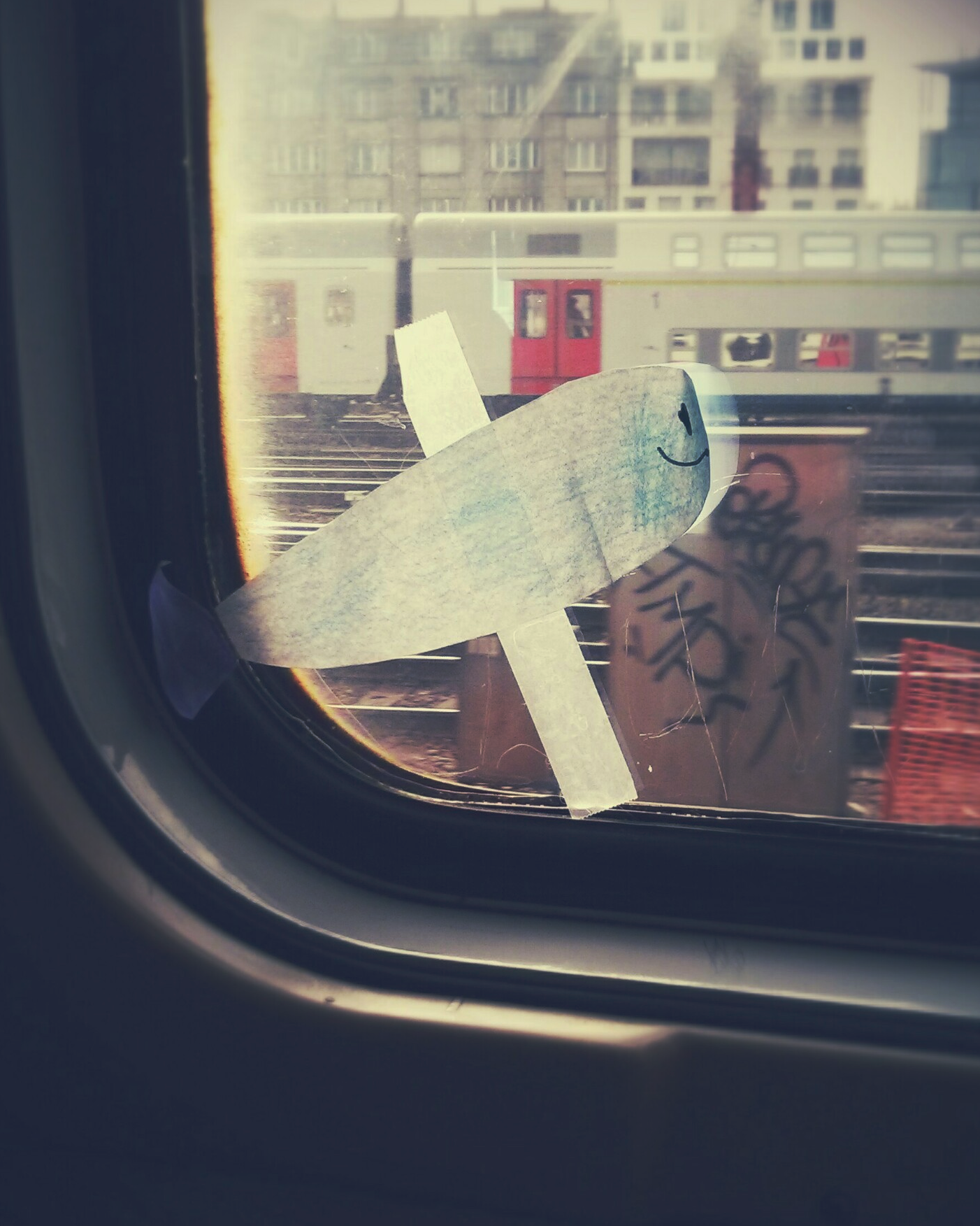Un poisson d'avril en papier, collé sur la fenêtre d'un train